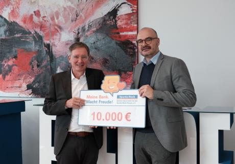 Rüdiger Orth (links) übergibt die Spende an Dr. Patrick Liesching (rechts)